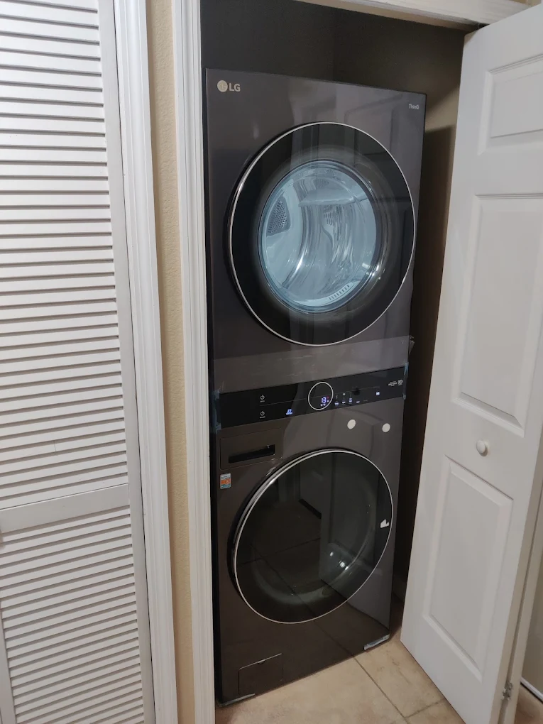 Dark LG laundry tower fitted inside a laundry closet