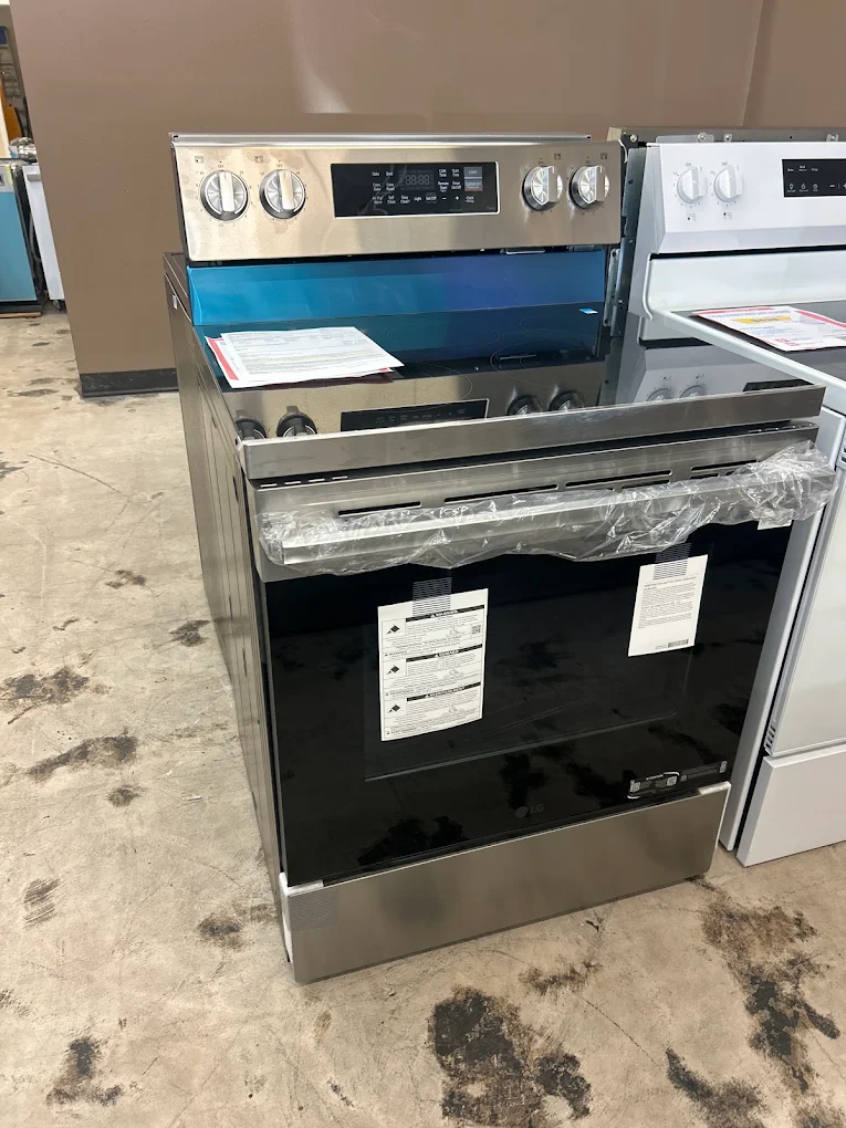 Stainless steel LG electric range displayed beside a white range in the showroom
