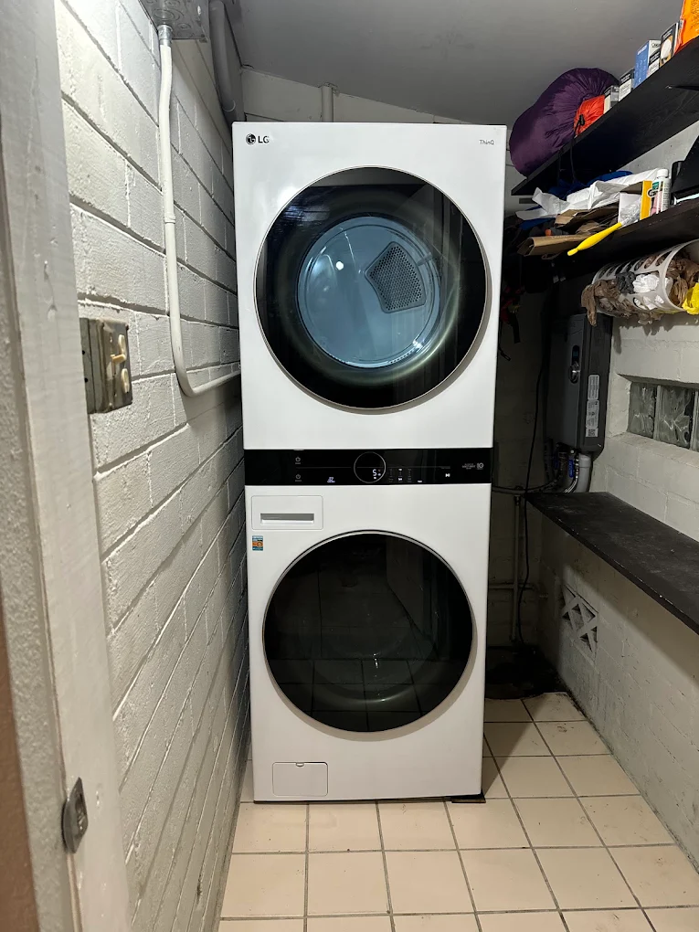 White LG laundry tower installed in a narrow laundry room